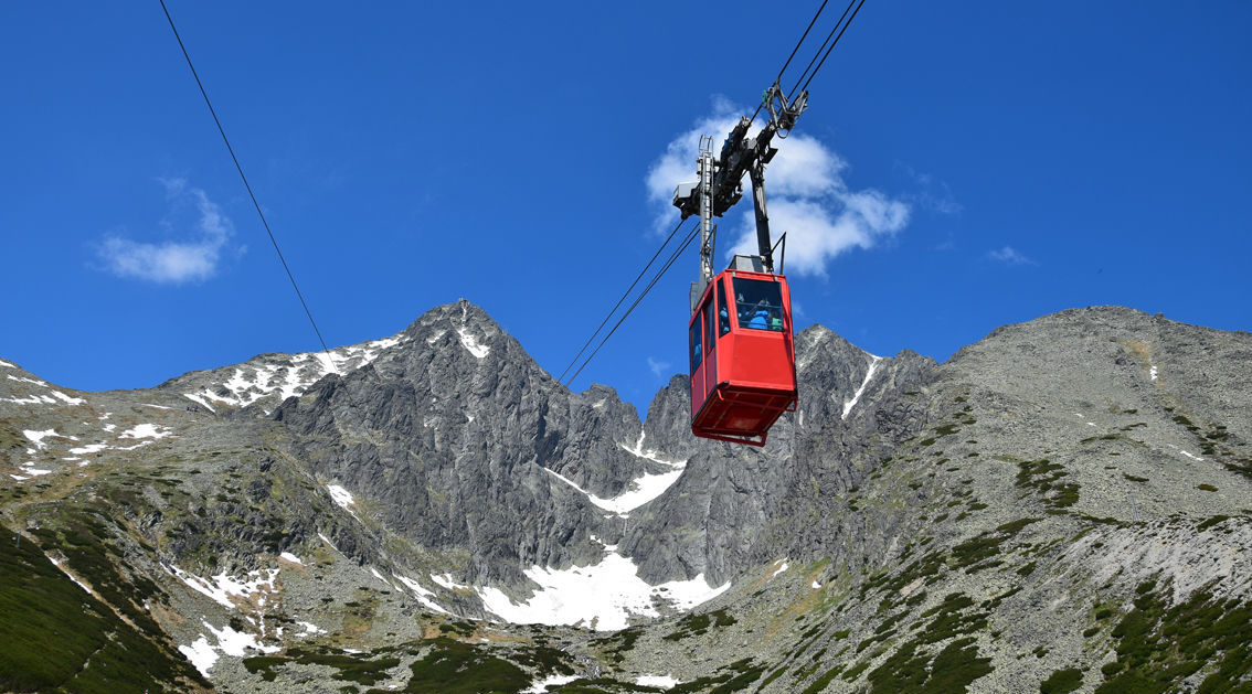Červená lanovka smerujúca zo Skalnatého plesa...