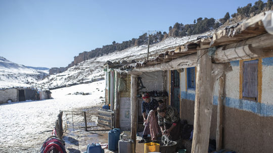 Ženy perú oblečenie pri dome, ktorý je...