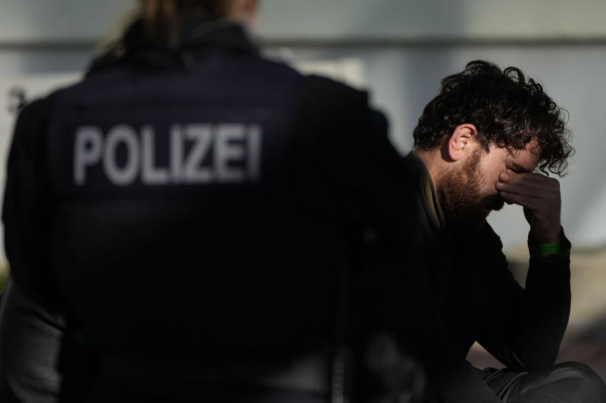 Ein Polizist bewacht einen inhaftierten Migranten...