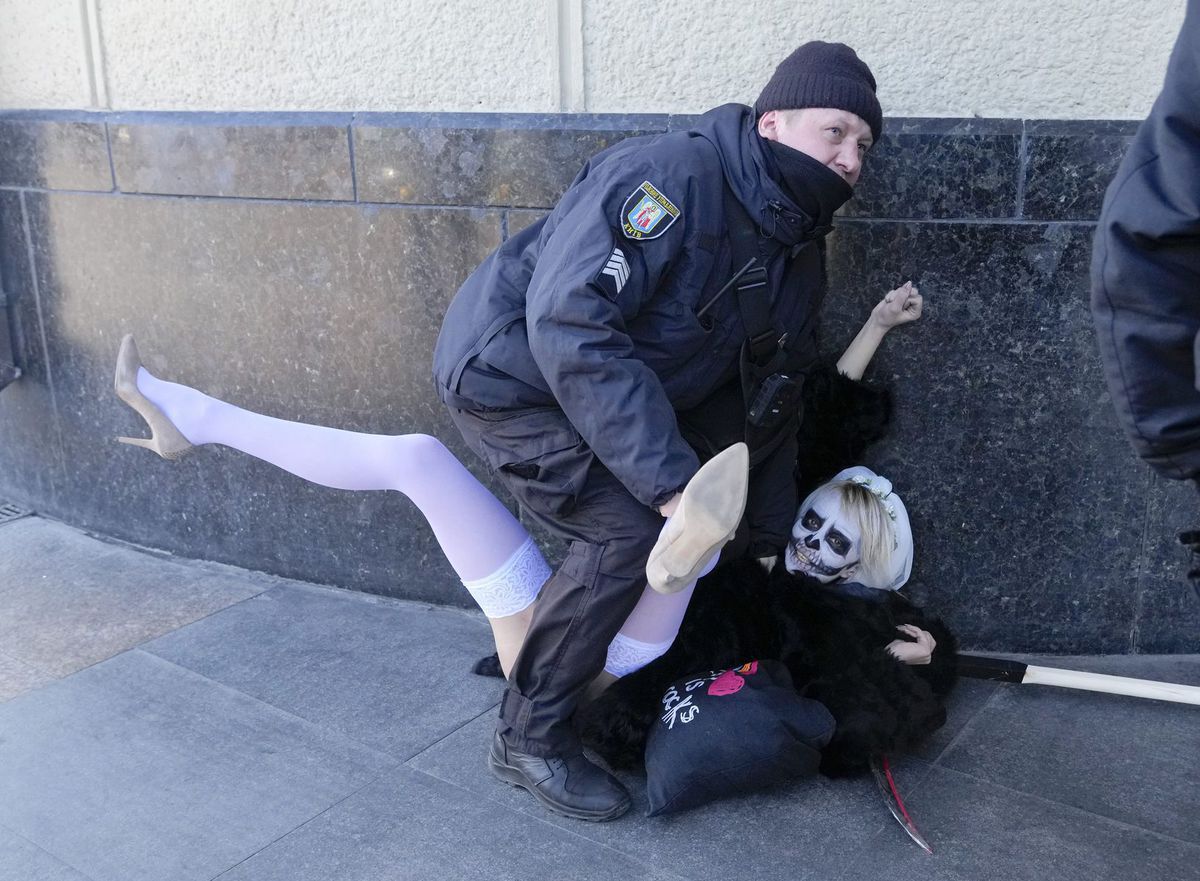 Policajt zatýka aktivistku hnutia Femen počas...