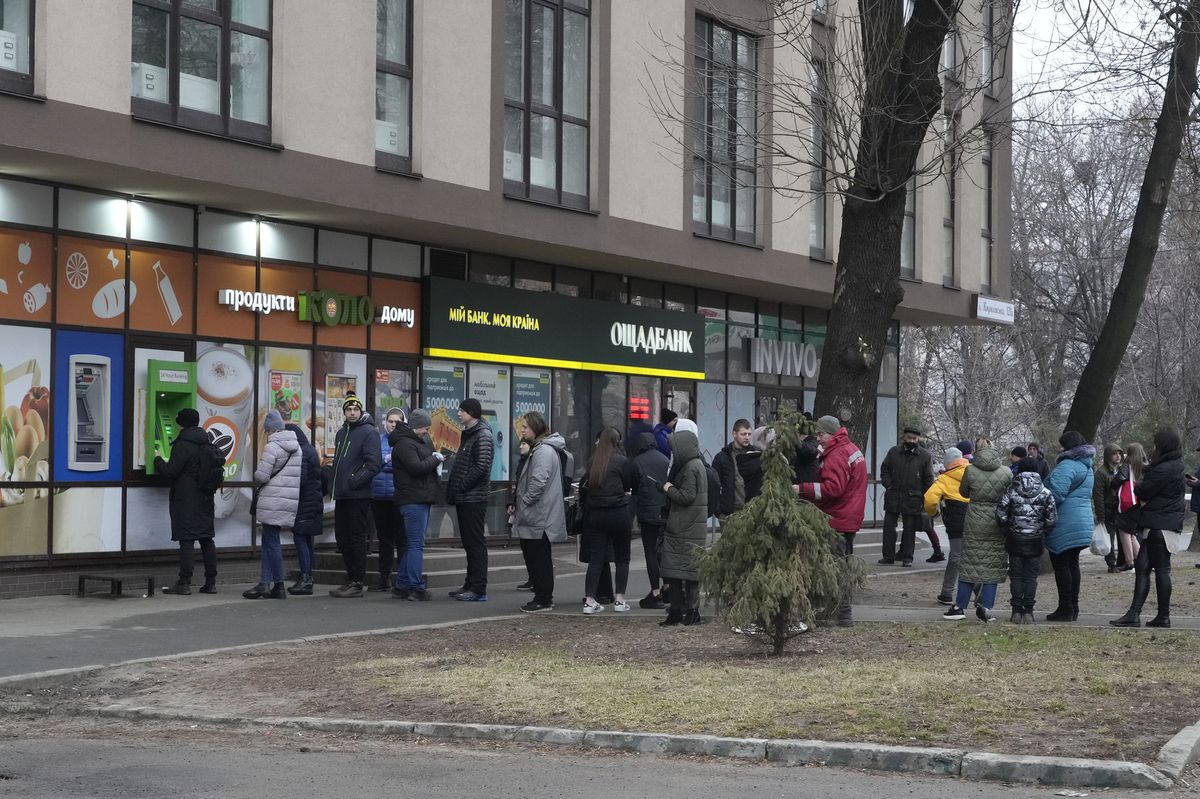 Ľudia pred bankomatom v Kyjeve vo štvrtok 24....
