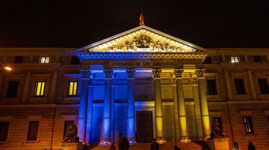 Ľudia kráčajú pred španielskym parlamentom...