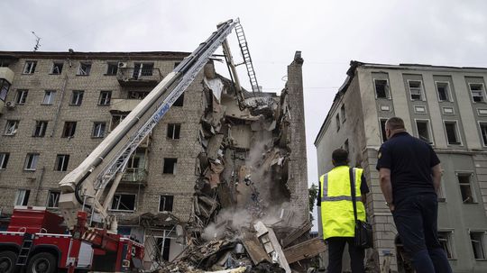 Záchranári a hasiči odpratávajú trosky zničenej...