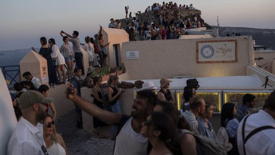 Turisti na ostrove Santorini, v dedine Oia, sa...