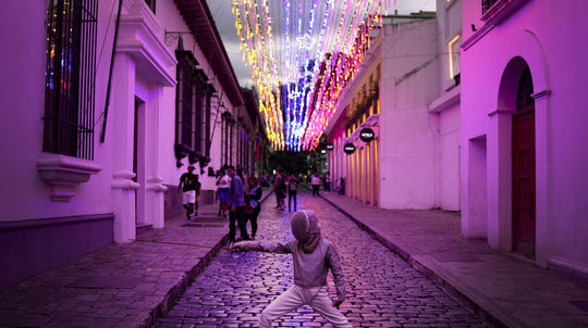 Mladý šermiar pózuje svojim rodičom pri fotení...