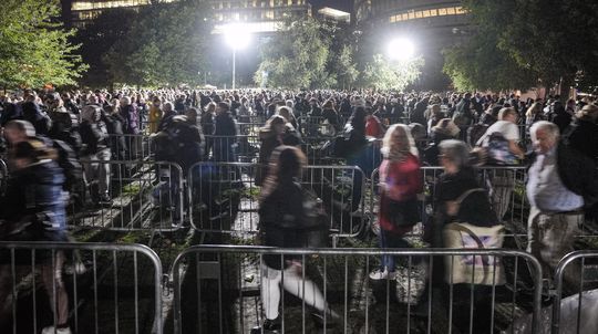 Ľudia stoja na začiatku veľmi dlhého radu, aby...