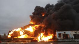 Dym a oheň stúpajúci z horiacich nádrží po...