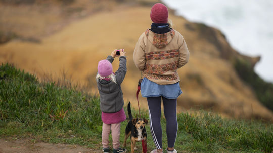 Rodinka pozoruje z vrcholu útesu surfistov...