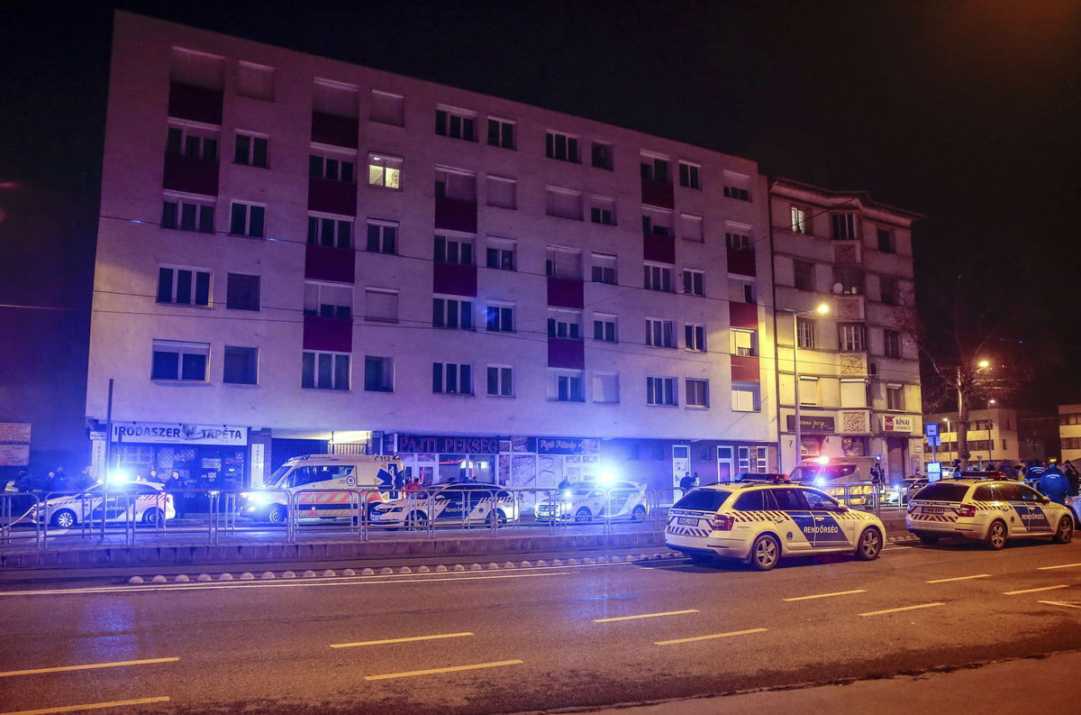 Policajné autá blokujú cestu pred obytným domom...
