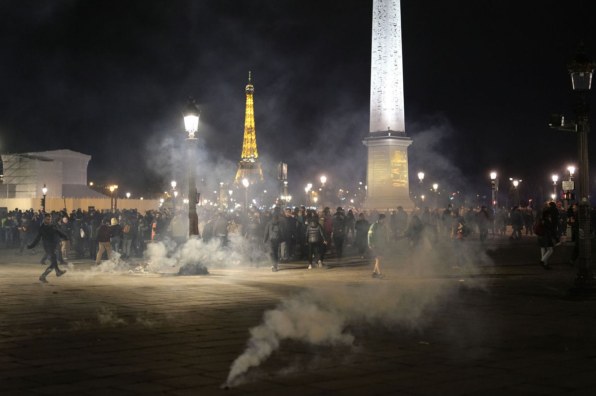 Des manifestants se tiennent dans un nuage de gaz lacrymogène après...