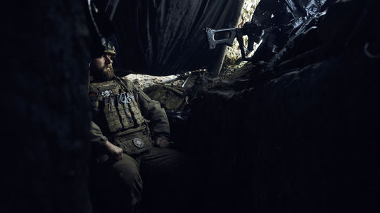 Ukrajinský vojak pozoruje dianie na fronte zo...