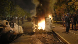 Des policiers se promènent dans des voitures en feu dans la ville...