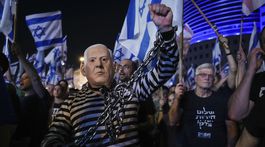 Demonštrant v maske s podobizňou izraelského...