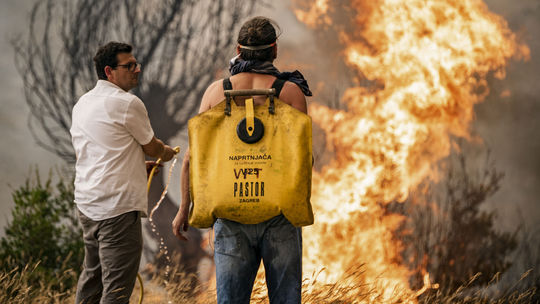 Dobrovoľníci sa snažia uhasiť požiar pod...