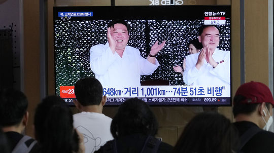 Ľudia sledujú v televízii na železničnej...