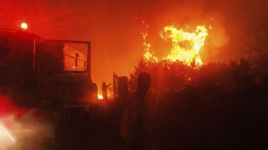 V oblasti požiarov v Grécku sa našlo 18 spálených tiel, zrejme ide o migrantov