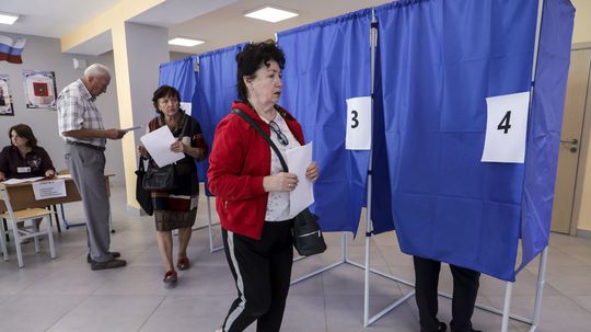 Voliči hlasujú počas miestnych volieb v...