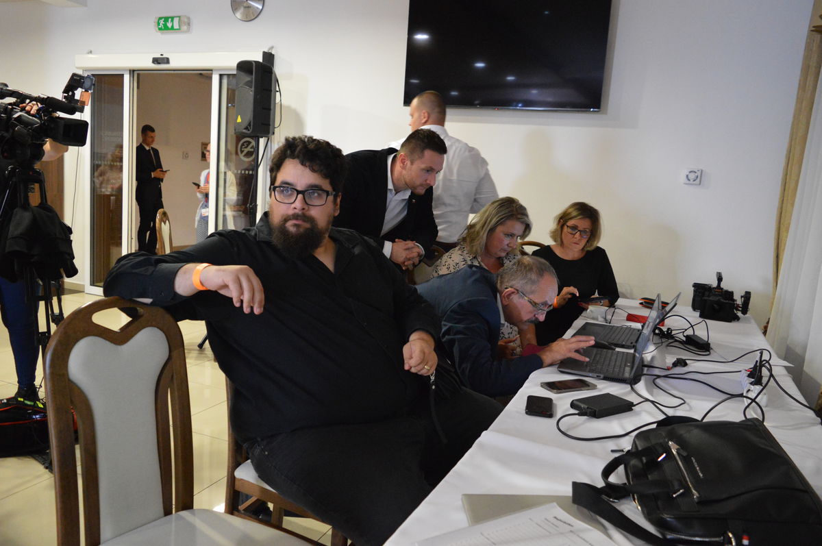 Líder Republiky Milan Uhrík (v pozadí) sleduje...