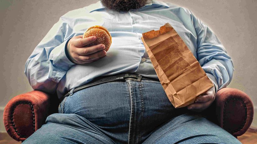 tučný chlap s hamburgerom
