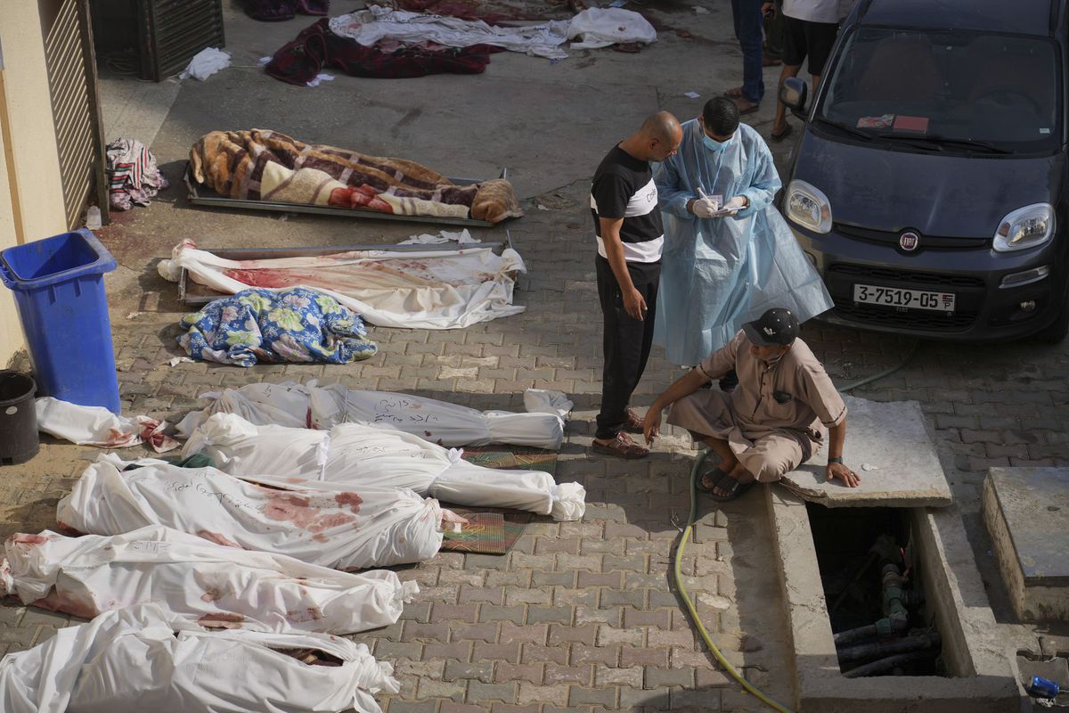 Muž sedí pri obetiach izraelského bombardovania...