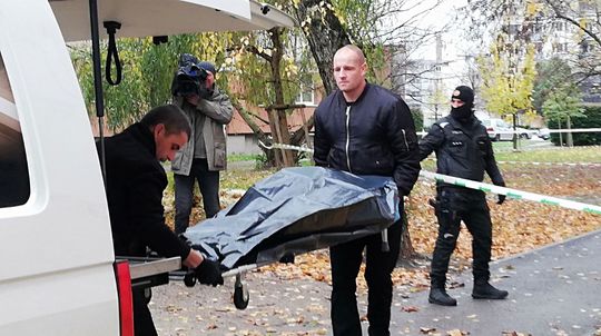Pohrebná služba odnáša telo jednej z obetí...
