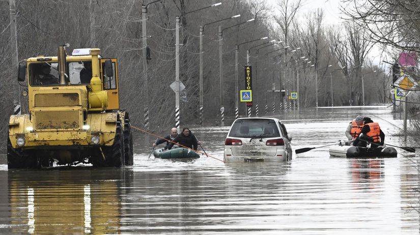 Ľudia používajú gumové člny na zaplavenej ulici...
