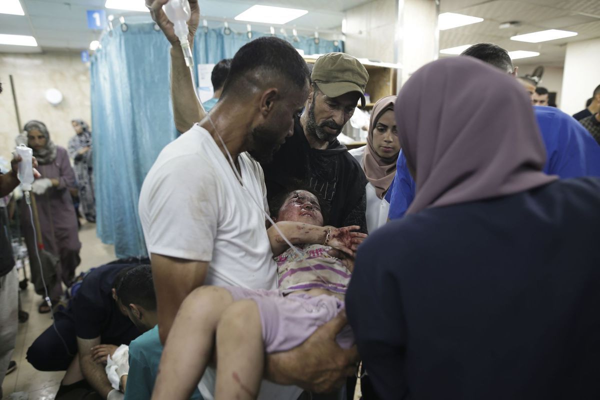 Palestínčan nesie zranené dievča do nemocnice...