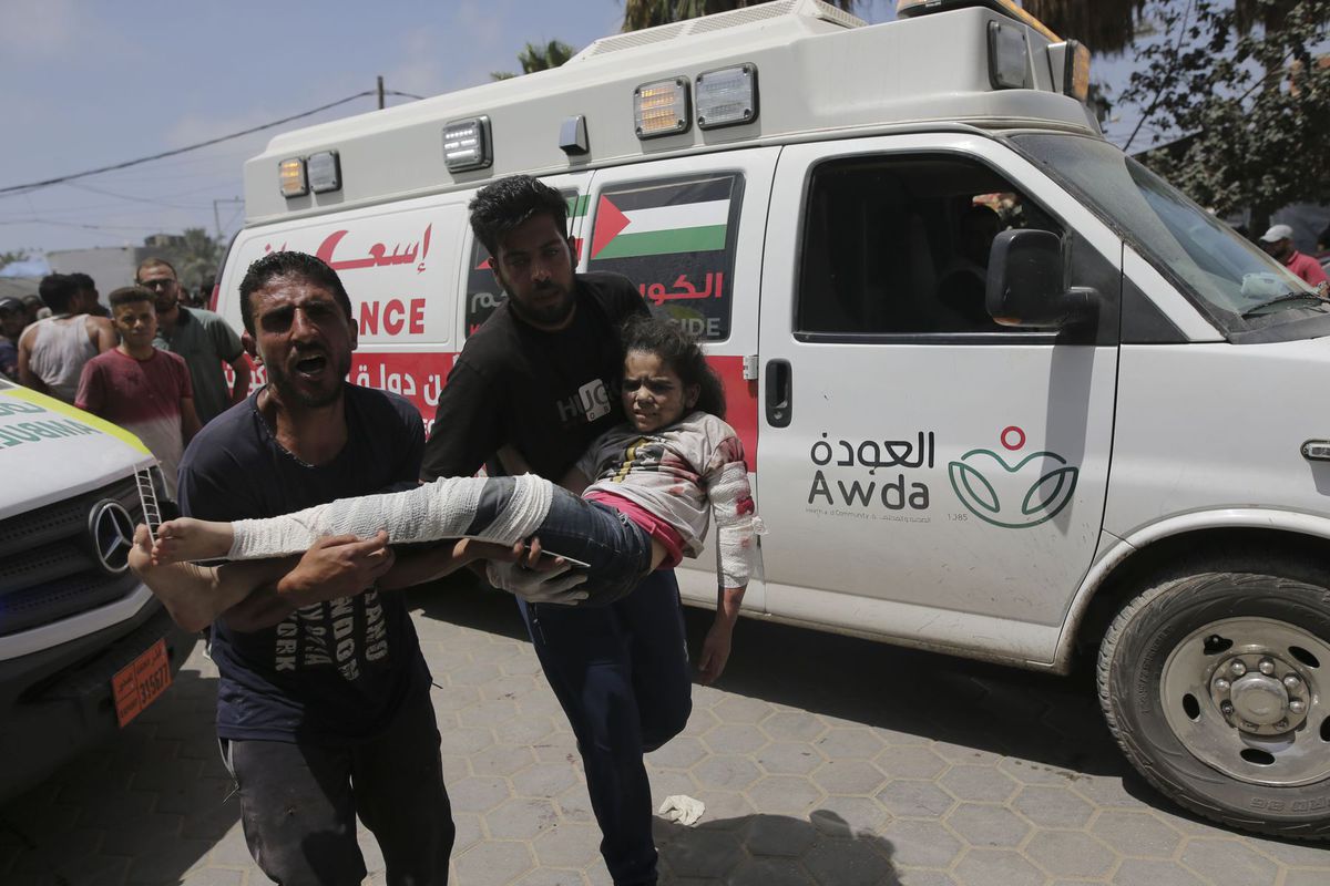 Palestínčan nesie zranené dievča do nemocnice...