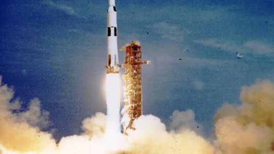 The launch of the Saturn V rocket, which carried the crew...