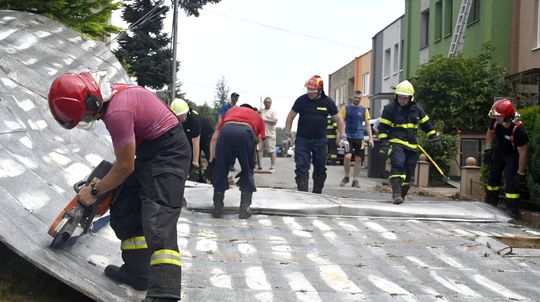 Na snímke strhnuté strechy domov po búrke a...