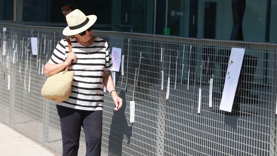 Okoloidúci si chodia čítať odkazy na plote pri...