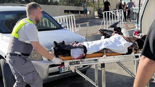 Príslušník civilnej obrany odnáša zraneného...