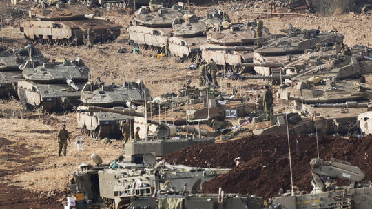 Israeli soldiers work on tanks in the north...