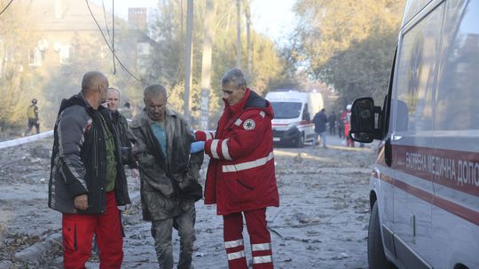 The rescuers help the injured man to board...