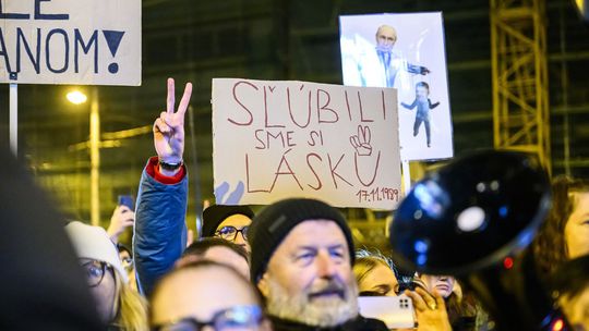 Ľudia držia transparenty počas zhromaždenia...