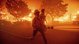 A wildfire threatens the Pacific Palisades neighborhood in...