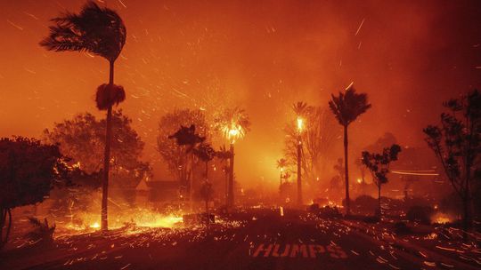 A wildfire threatens the Pacific Palisades neighborhood in...