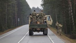 U.S. soldiers stand in the back of a truck on a...