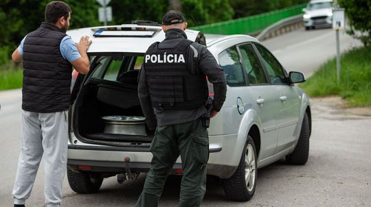 Na snímke policajné kontroly a prehľadávanie...