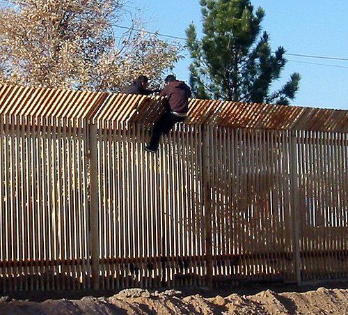 Migranti z Mexika prekonávajú plot na hranici v...