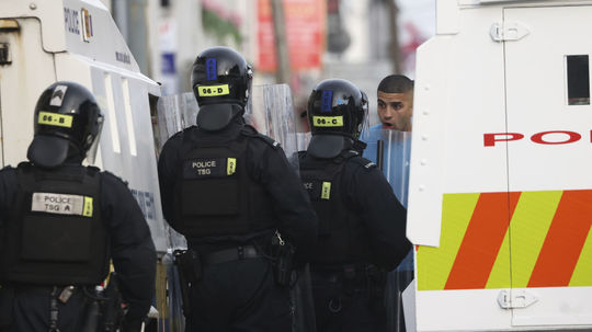 Polícia v zásahovej výstroji sa rozpráva s...