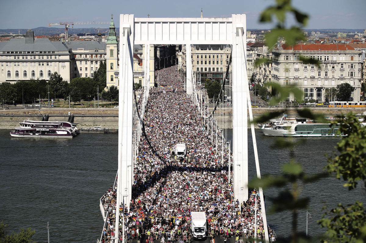 Účastníci pochodu Pride prechádzajú cez most...