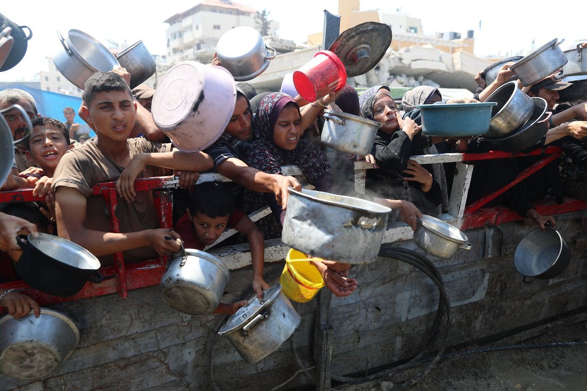 Palestínčania v meste Gaza čakajú na jedlo,...