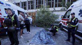 Policajt spisuje poznámky nad telom obete po...