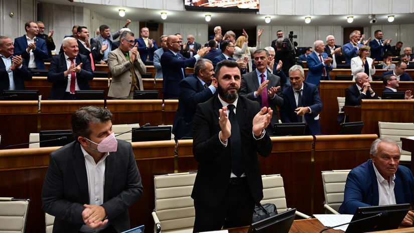 Koaliční poslanci a v pozadí vpravo poslanci...