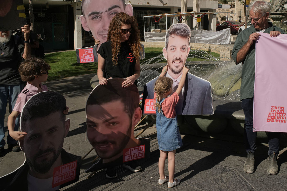 Dievča sa dotýka transparentu s portrétom...