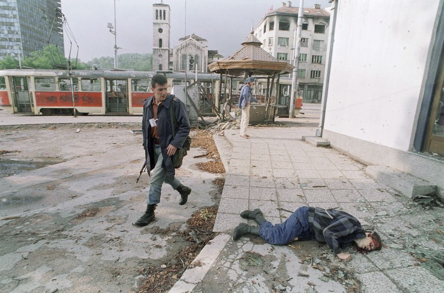 Príslušník bosnianskej milície prechádza okolo...