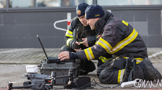 Na snímke hasiči analyzujú zábery z dronu na...