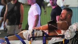 Záchranár odnáša na nosidlách zraneného muža po...